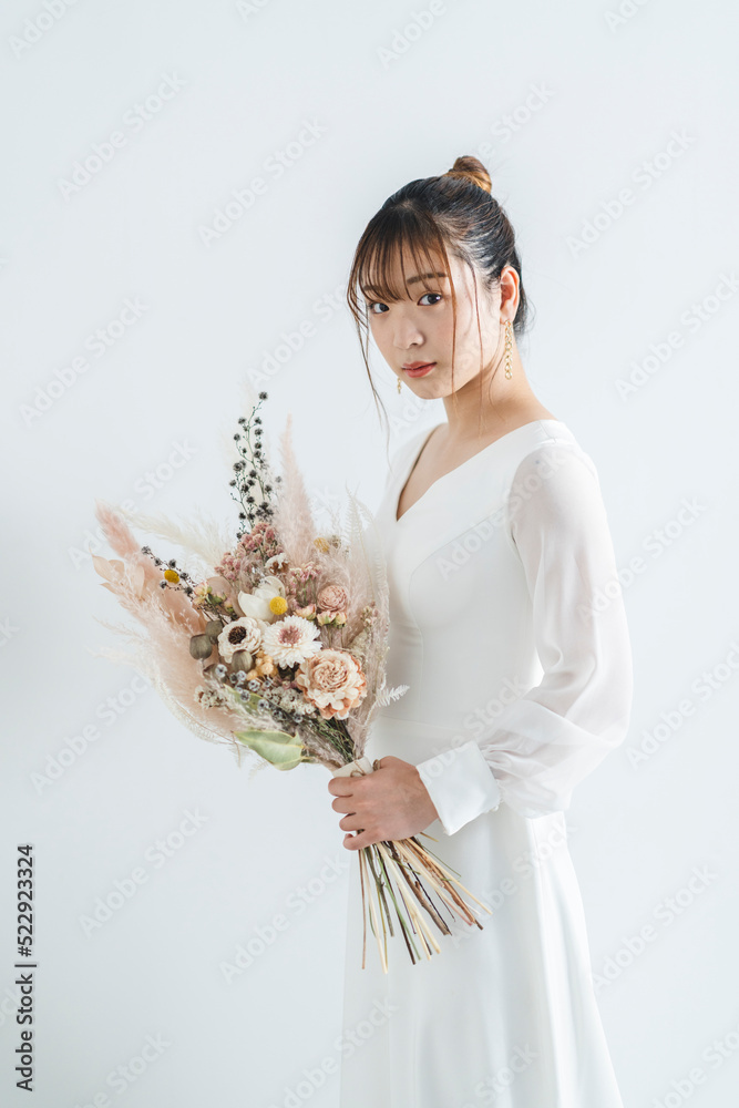 ウェディングドレスを着てブーケを持った花嫁