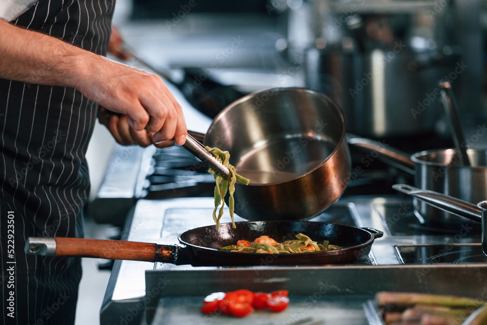 Busy at work. Chef is on the kitchen preparing food Busy at work. Chef is on the kitchen preparing food