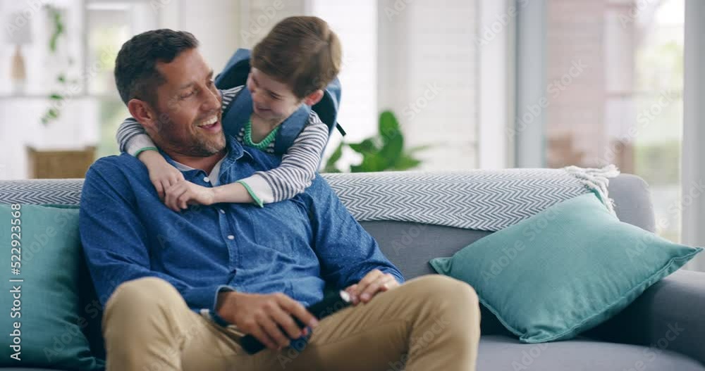 Excited, happy son running and hugging his surprised father on the living room sofa after school. Single parent relaxing and watching tv, waiting for his young child to come to their family home Excited, happy son running and hugging his surprised father on the living room sofa after school. Single parent relaxing and watching tv, waiting for his young child to come to their family home