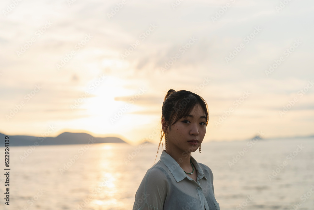 夕暮れの海を散策する女性 夕暮れの海を散策する女性