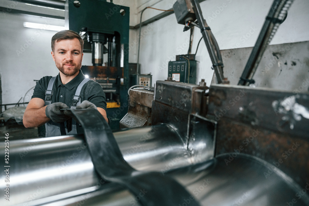 Fototapeta premium Professional engineer operating machine. Man in uniform is in workstation developing details of agriculture technique