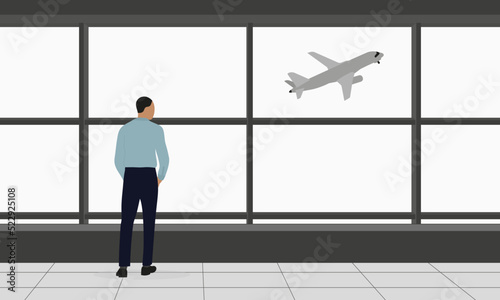 A male character in business clothes stands and looks out the window at a plane taking off