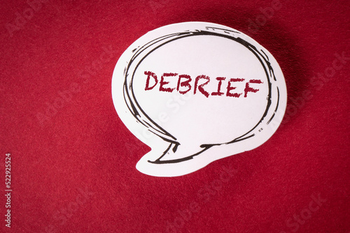DEBRIEF. Text on speech bubble and red background photo