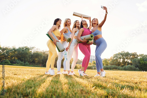 Taking a selfie. Group of women have fitness outdoors on the field together