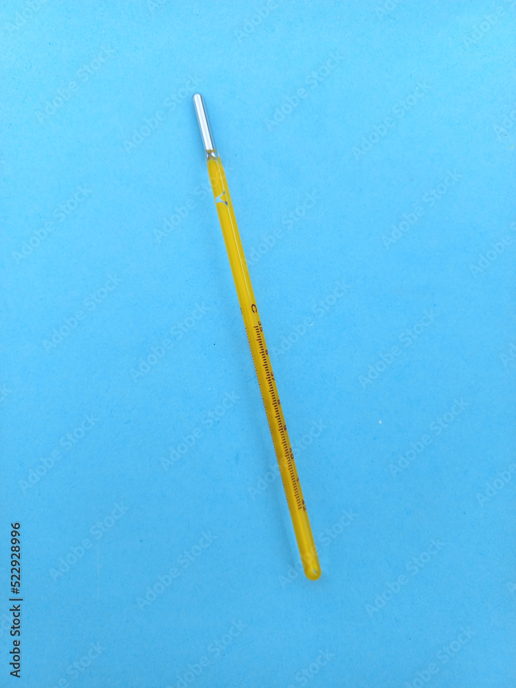 glass thermometer on blue background