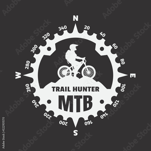 Mountain biker, logo in the form of a compass on a dark background. Vector illustration.