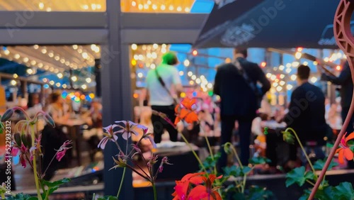 Defocused backside view: Band is performinhg on a terrace at a night city bar
