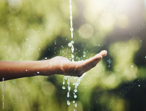 Hygiene, washing and saving water with hands against a green nature background. Closeup of one person holding out their palm to save, conserve and refresh with water in a park, garden or backyard