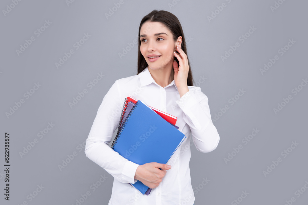 Smiling young woman college student holding book on isolated gray background. Model emotionally showing facial expressions. Smiling young woman college student holding book on isolated gray background. Model emotionally showing facial expressions.