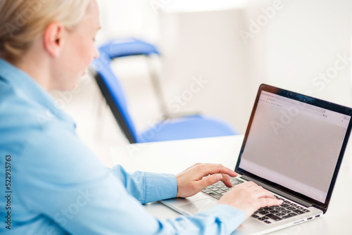 Back view of business women hands busy using laptop at office desk.