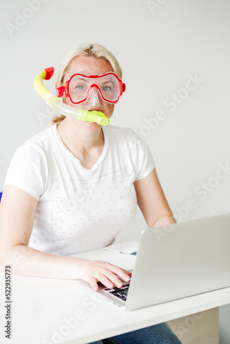 Woman in diving mask seeking offers on-line for your vacation on the beach.