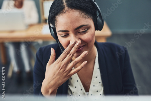 Young call centre agent covers their mouth to hide their smile. The client makes the employee happy with their positive feedback or joke. Building a professional and friendly relationship online.