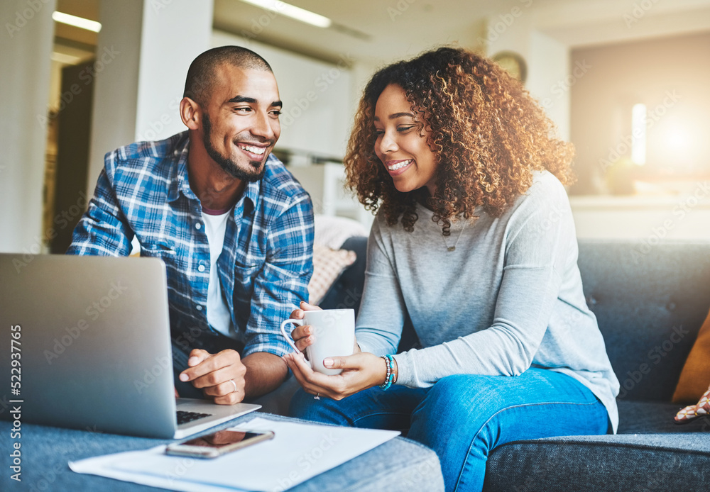 Fototapeta premium Home finance, savings and investment with a young couple working on a laptop in their living room. Man and woman calculating a household budget together while relaxing and drinking coffee on the sofa