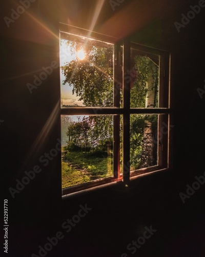 A beautiful summer view from finnish sauna window. Sunbeams shining through window.