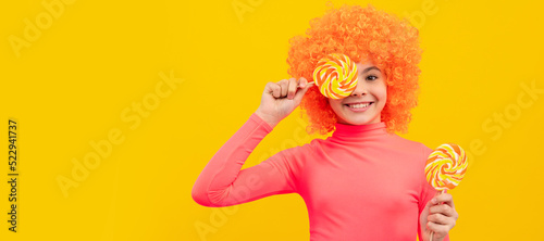 Happy girl child with orange hair in pink poloneck have fun holding lollipops, girlhood. Funny teenager child on party, poster banner header with copy space.