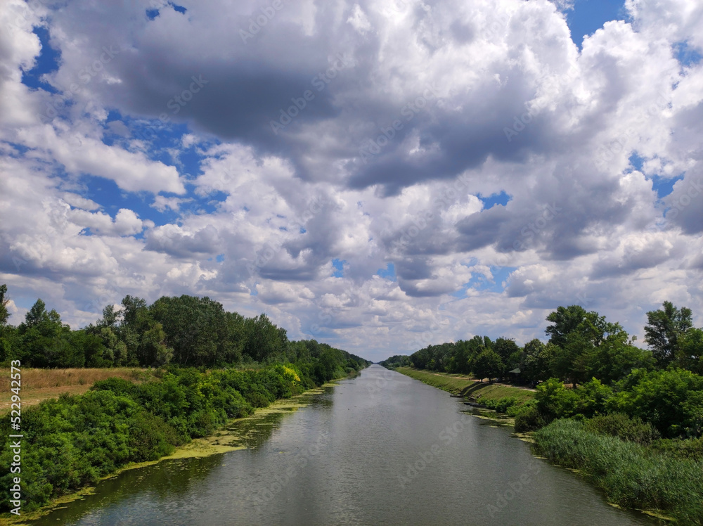 rural landscape by the river with blue sky and white clouds