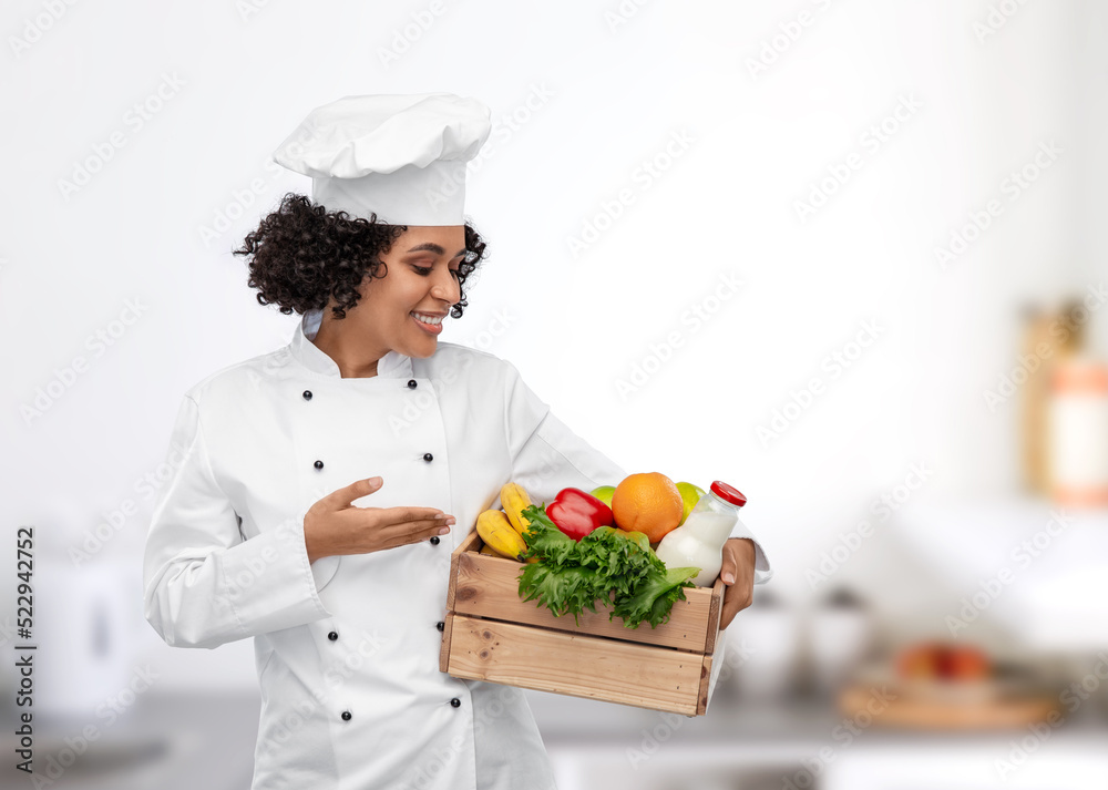 cooking, culinary and people concept - happy smiling female chef in toque holding food in wooden box over restaurant kitchen background cooking, culinary and people concept - happy smiling female chef in toque holding food in wooden box over restaurant kitchen background