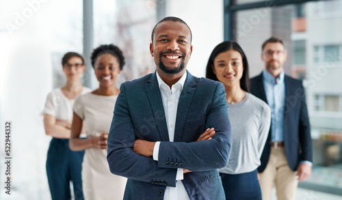 Professional, diverse and successful business team smiling and standing together in an office. Happy, formal and multiracial corporate staff, bank workers or businesspeople looking at camera. photo