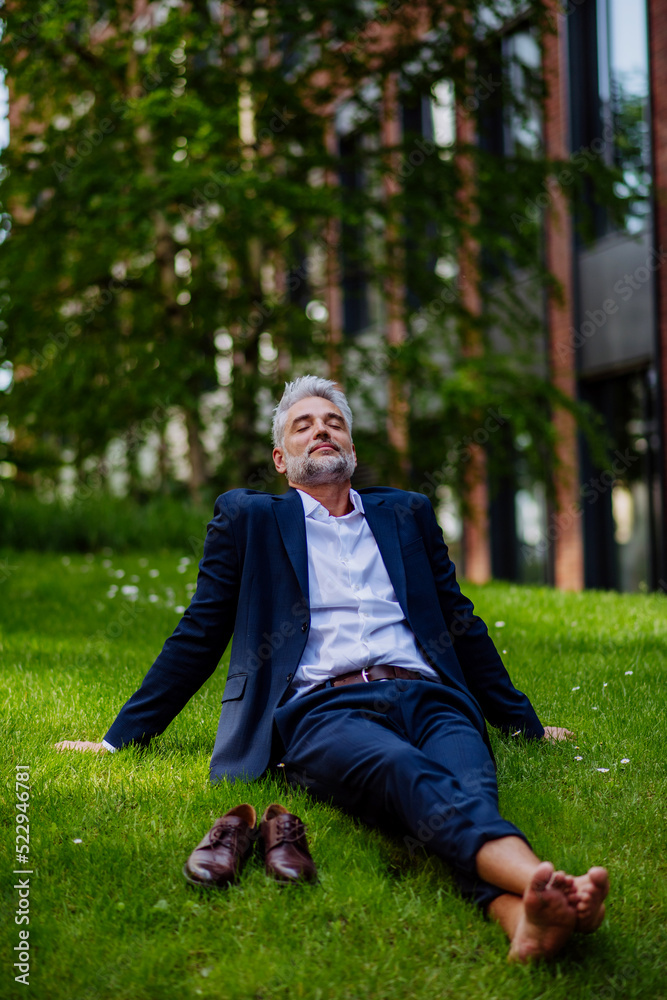 Mature businessman resting and sitting barefoot in park, feeling free, escaping from work, work life balance concept. Mature businessman resting and sitting barefoot in park, feeling free, escaping from work, work life balance concept.
