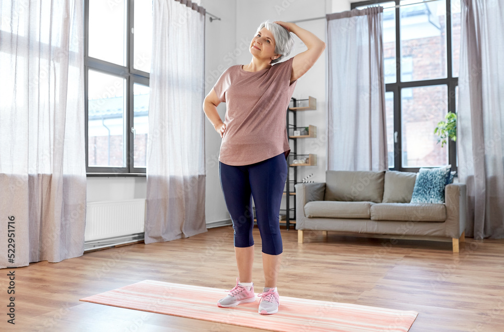 sport, fitness and healthy lifestyle concept - close up of smiling senior woman exercising on mat and stretching neck at home sport, fitness and healthy lifestyle concept - close up of smiling senior woman exercising on mat and stretching neck at home