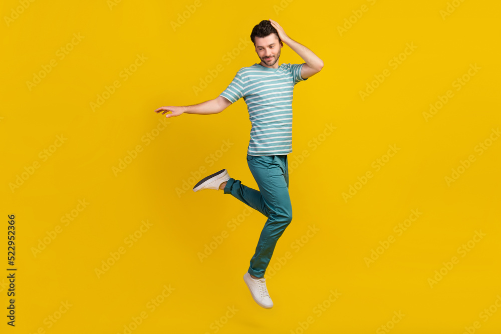 Full size photo of cool guy jump wear t-shirt jeans shoes isolated on yellow color background