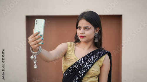 Photography Beautiful Indian girl taking selfie on her mobile phone outdoor, cheerful Asian
