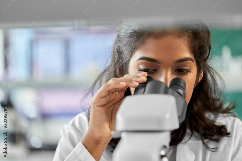 science research, work and people concept - close up of female scientist with microscope working in laboratory