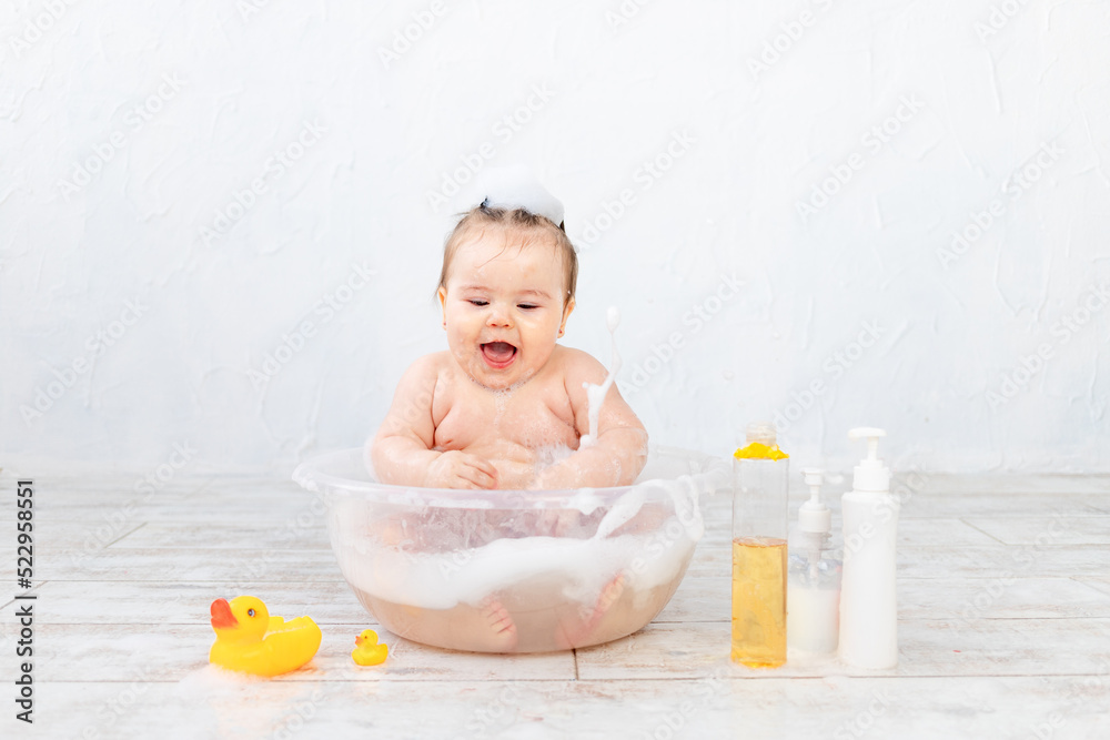 baby washes in a bowl with foam, space for text on bottles, baby hygiene baby washes in a bowl with foam, space for text on bottles, baby hygiene