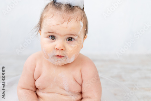 portrait of a baby in foam, bathing and hygiene of the baby