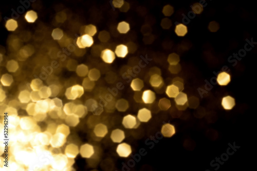 Golden blurred bokeh lights on black background. Glitter sparkle stars for celebrate. Overlay for your design