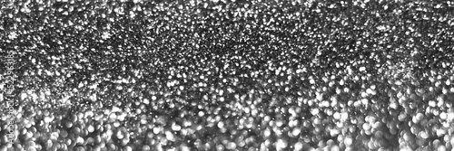 Gray silver sparkling glitter bokeh background, christmas abstract defocused texture. Holiday lights. Snowy shiny sparkle stars header. Wide screen wallpaper. Panoramic web banner with copy space
