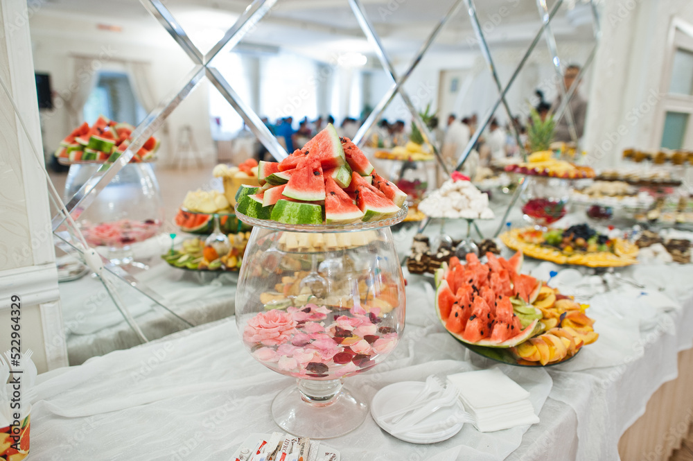 Beautiful wedding candy bar with sweets, fruits and food. Wedding banquet table Beautiful wedding candy bar with sweets, fruits and food. Wedding banquet table