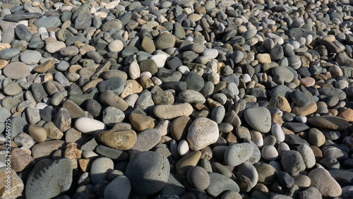 Sea stones background with small pebbles or stone in garden or in the seaside or on a beach. A close up view of rounded smooth polished pebble stones