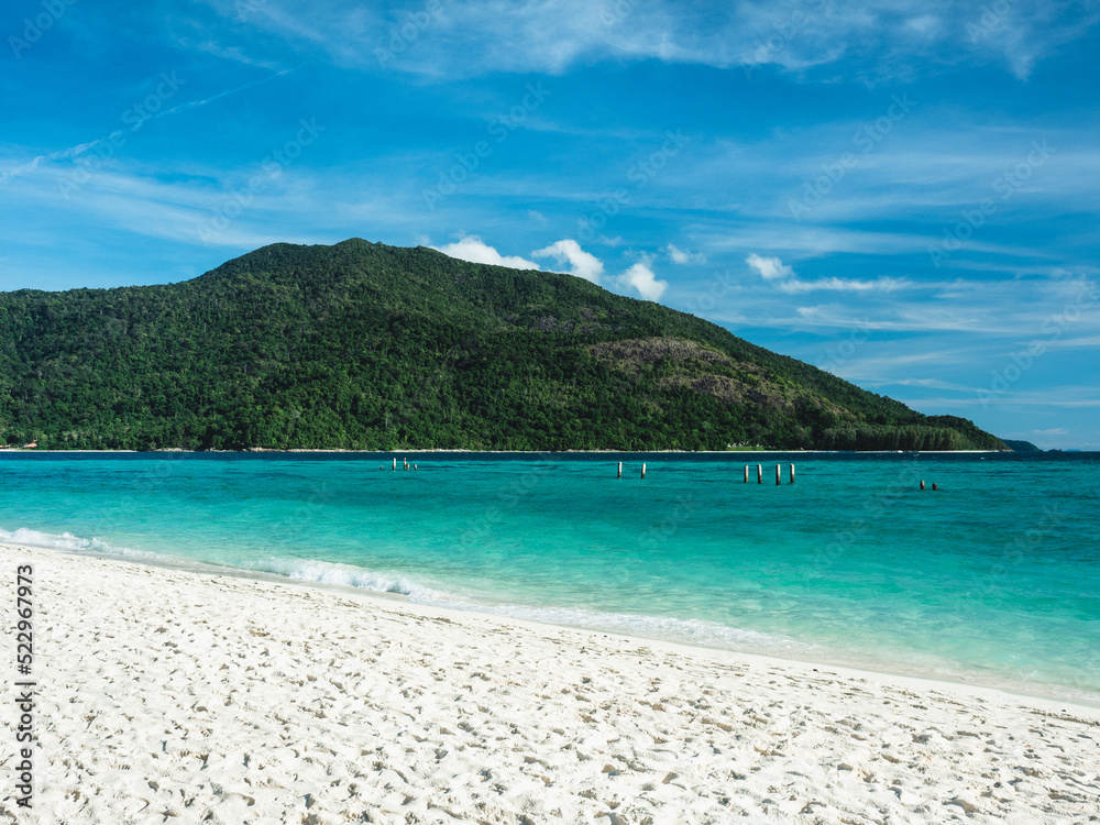 Scenic view of Sunrise Beach, Koh Lipe Island. White sand beach tropical island with crystal clear turquoise sea water against summer blue sky and Koh Adang Island background. Satun, Thailand. Scenic view of Sunrise Beach, Koh Lipe Island. White sand beach tropical island with crystal clear turquoise sea water against summer blue sky and Koh Adang Island background. Satun, Thailand.