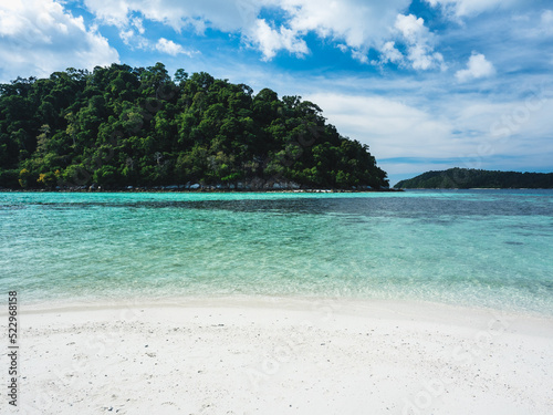 Fototapeta Naklejka Na Ścianę i Meble -  Scenic view of Koh Rokroy Island white sand beach with crystal clear turquoise sea water and coral reef against summer blue sky. Near Koh Lipe Island, Tarutao National Marine Park, Satun, Thailand.