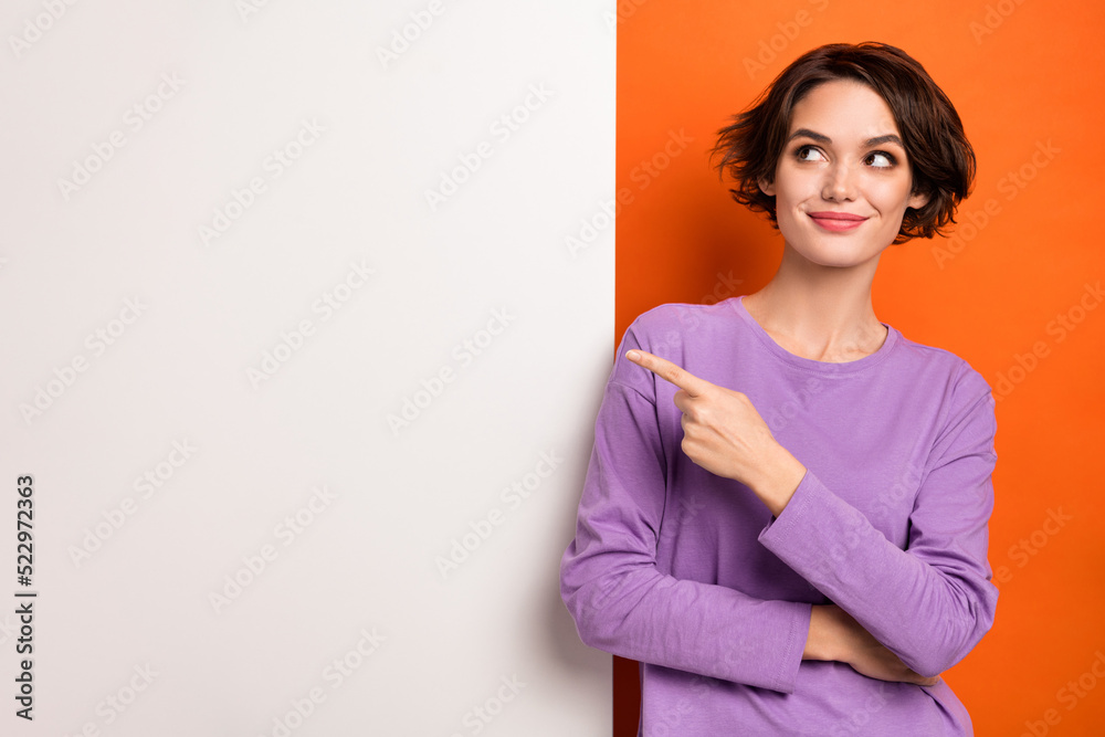Photo of dreamy cute lady wear violet sweatshirt showing finger white poster empty space isolated orange color background Photo of dreamy cute lady wear violet sweatshirt showing finger white poster empty space isolated orange color background