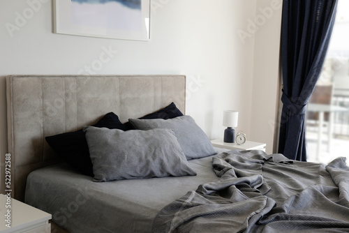 Foto Room with an empty king sized bed with headboard, perfectly clean and ironed sheets, puffy pillows in natural sun light