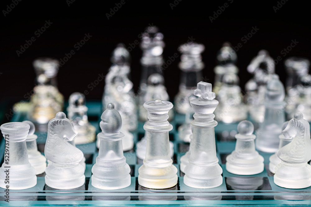 glass, transparent chess pieces on a checkerboard, selective focus, close-up, isolated on black glass, transparent chess pieces on a checkerboard, selective focus, close-up, isolated on black