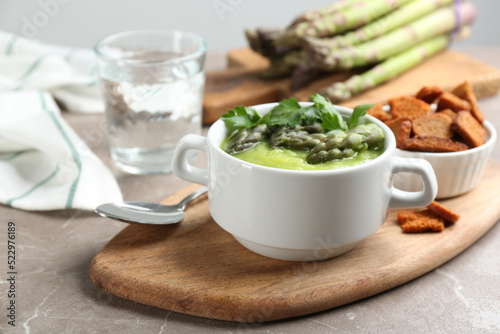 Delicious asparagus soup served on grey marble table