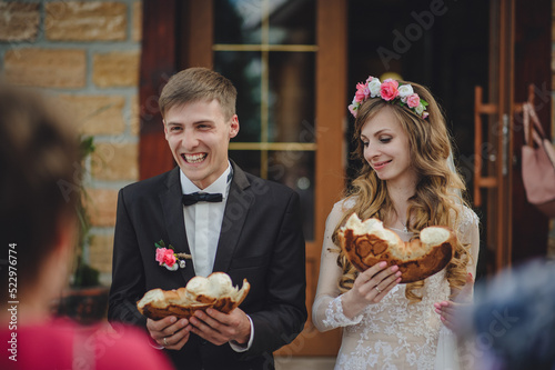 Close Up photo of bride and groom eating traditional loaf. Ukrainian and Russian wedding ceremony  wedding bread with salt.