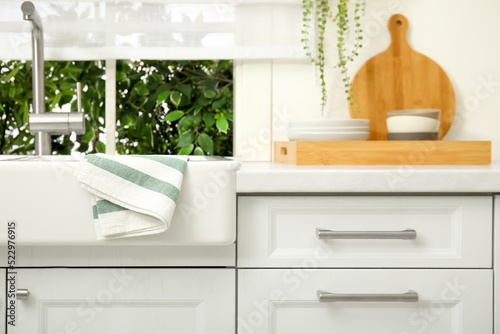 Clean towel hanging on white sink in kitchen