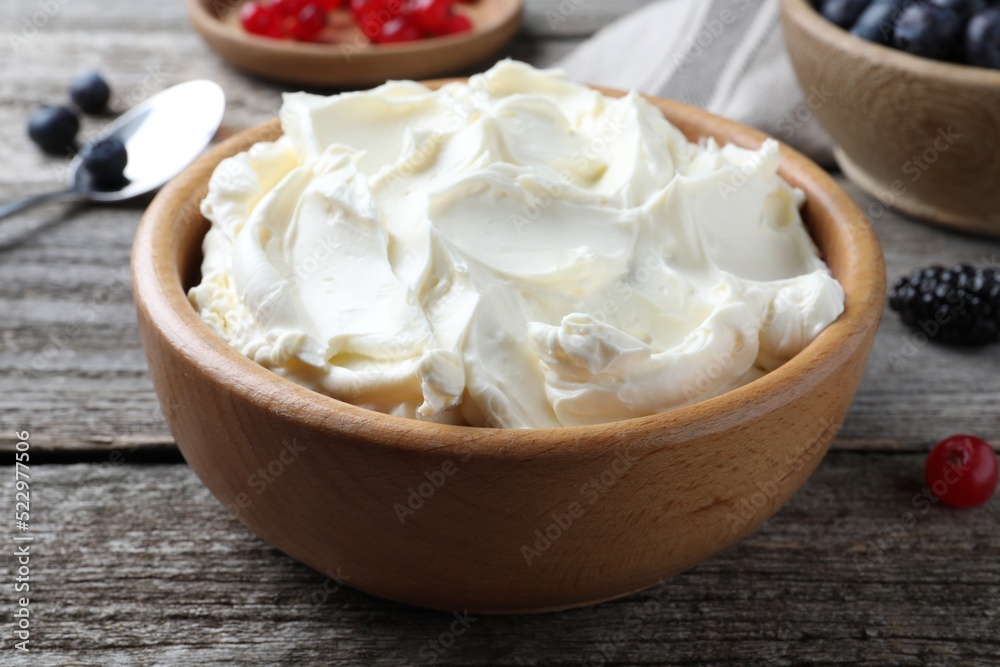 Tasty cream cheese and fresh berries on wooden table, closeup Tasty cream cheese and fresh berries on wooden table, closeup