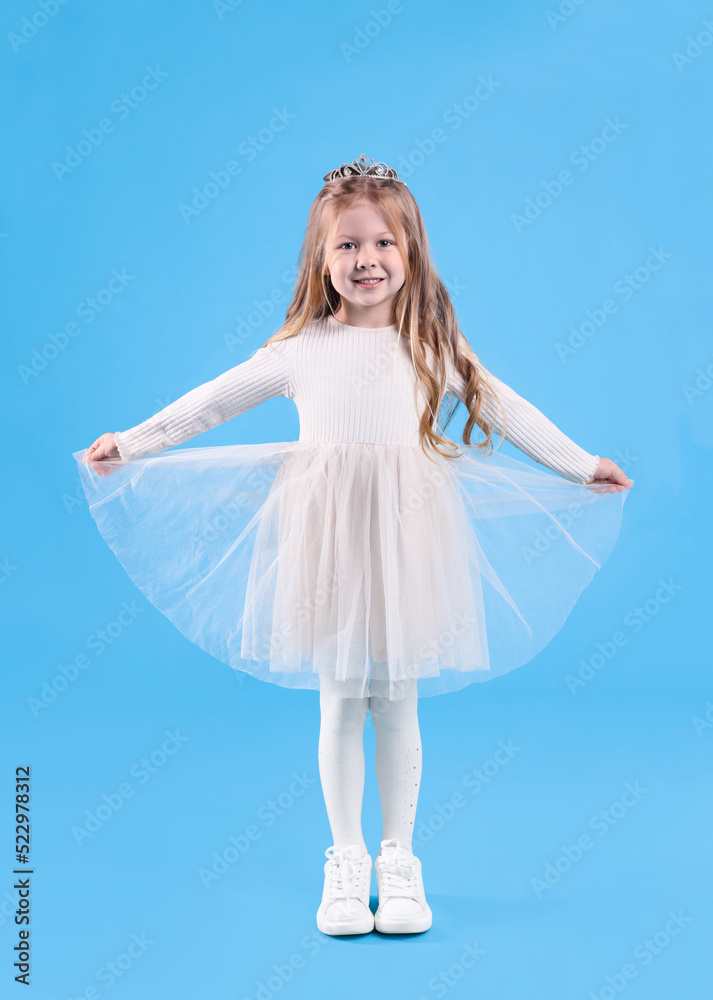 Naklejka premium Cute girl in beautiful dress with diadem on light blue background. Little princess