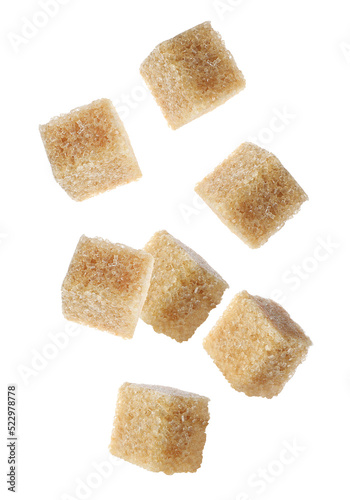 Flying cubes of brown sugar on white background