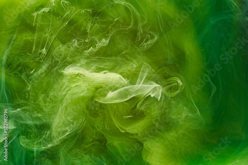 Liquid fluid art abstract background. Green dancing acrylic paints underwater, cosmic smoke ocean