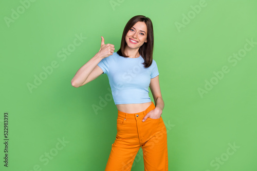 Portrait of positive pretty lady toothy smile demonstrate thumb up awesome isolated on green color background