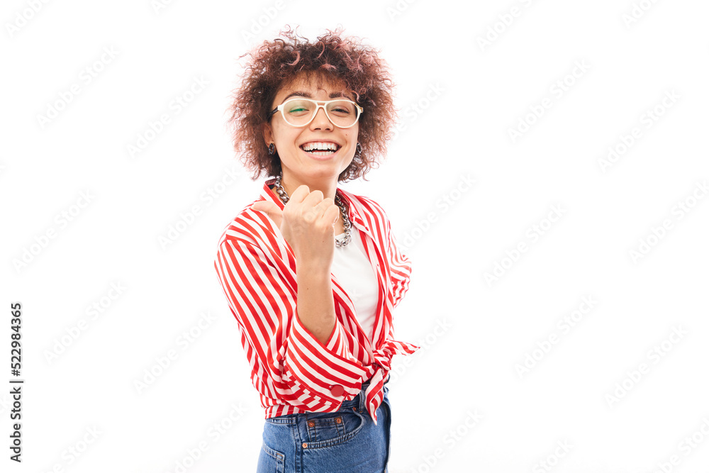 Positive kazakh girl with afro hairstyle points forefinger at copy space isolated on white studio background Positive kazakh girl with afro hairstyle points forefinger at copy space isolated on white studio background