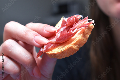 woman eating some toast with iberian cured ham
