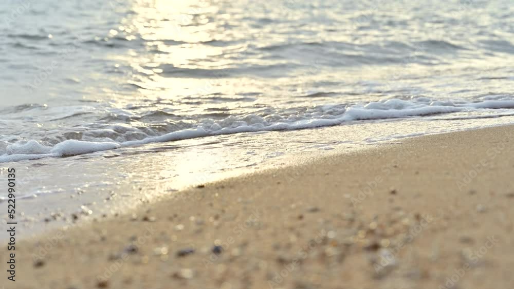 Close up soft wave water on sandy beach seaside during sunset. summer vacation activity background concept Close up soft wave water on sandy beach seaside during sunset. summer vacation activity background concept