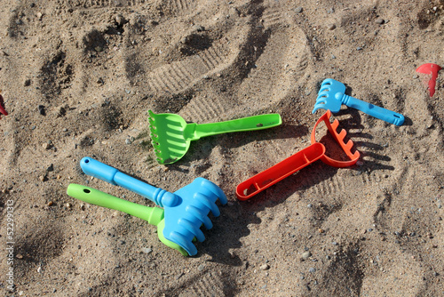 Plastic toy rake in the sandbox.